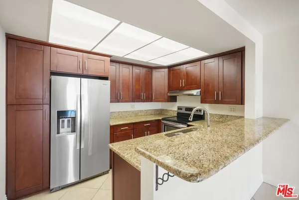 a kitchen with stainless steel appliances granite countertop a refrigerator sink and cabinets