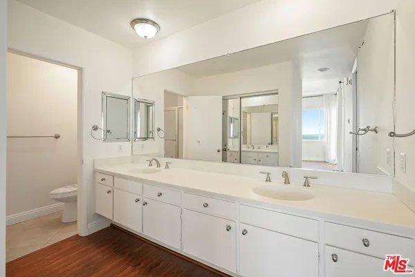 a bathroom with a double vanity sink mirror and toilet