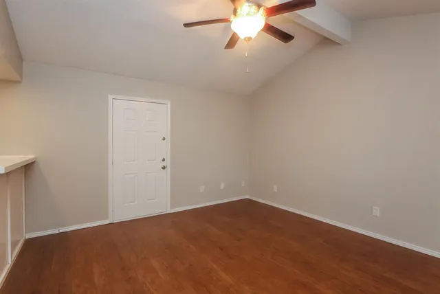 a view of an empty room with a chandelier fan
