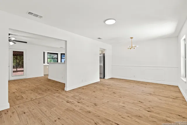 a view of empty room with wooden floor