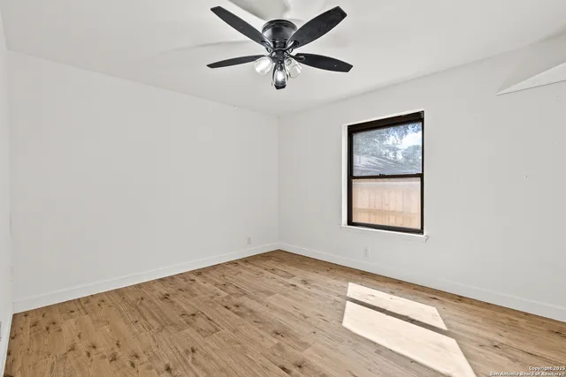 a view of a big room with wooden floor closet and chandelier fan