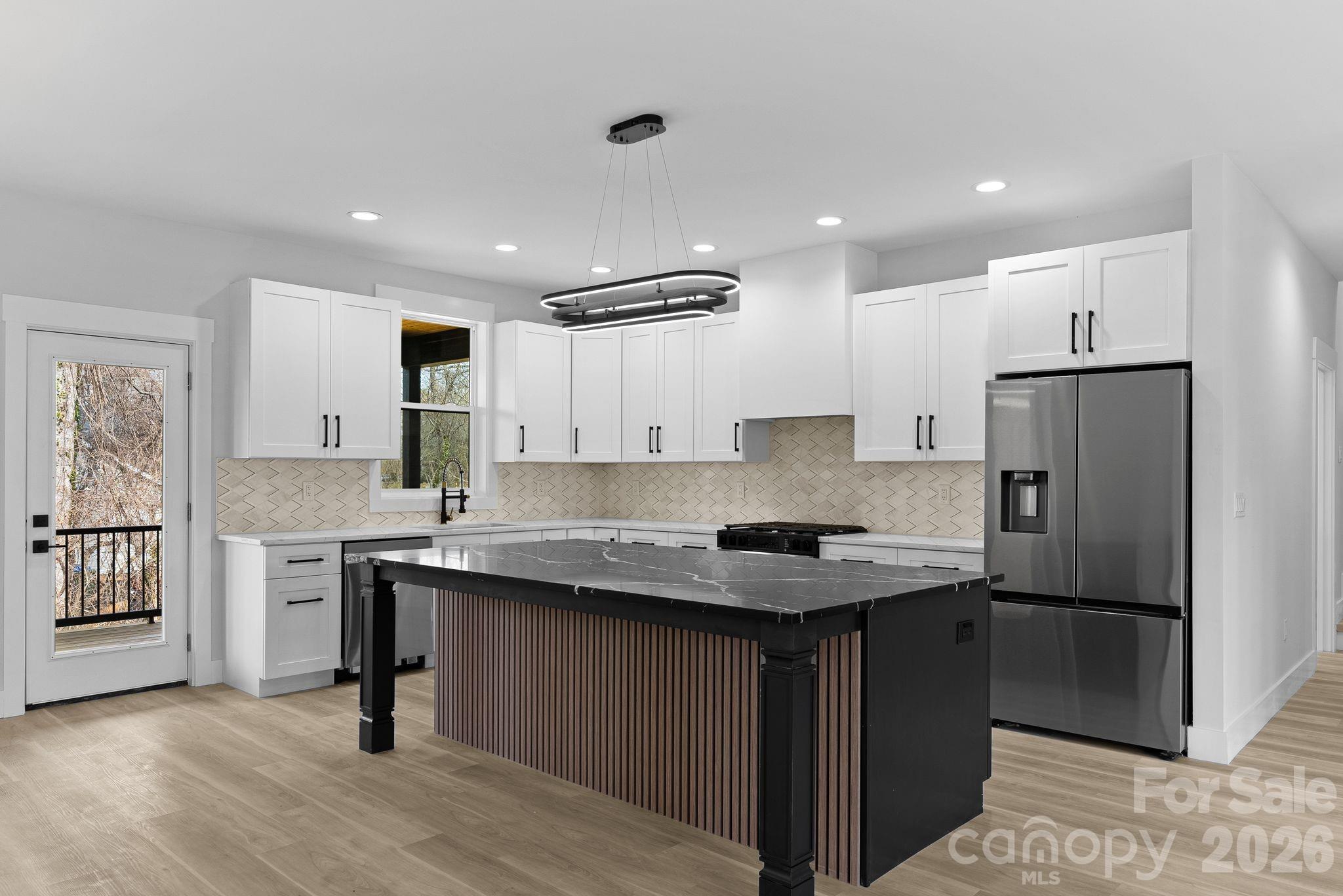 19 East Starnes Cove Road Asheville, NC 28806 - Photo 11 of 46 a kitchen with a refrigerator a sink dishwasher and a stove with wooden floor