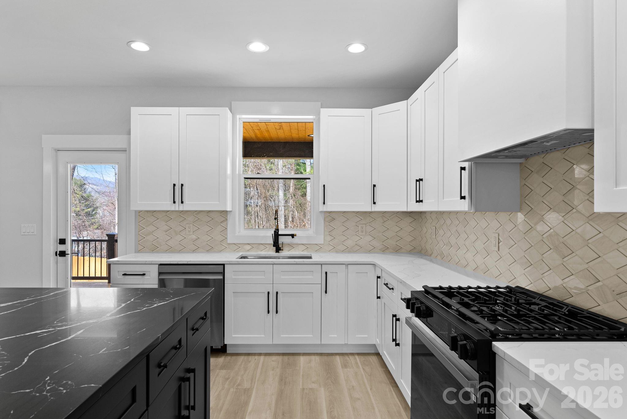 19 East Starnes Cove Road Asheville, NC 28806 - Photo 14 of 46 a kitchen with stainless steel appliances a sink stove and cabinets