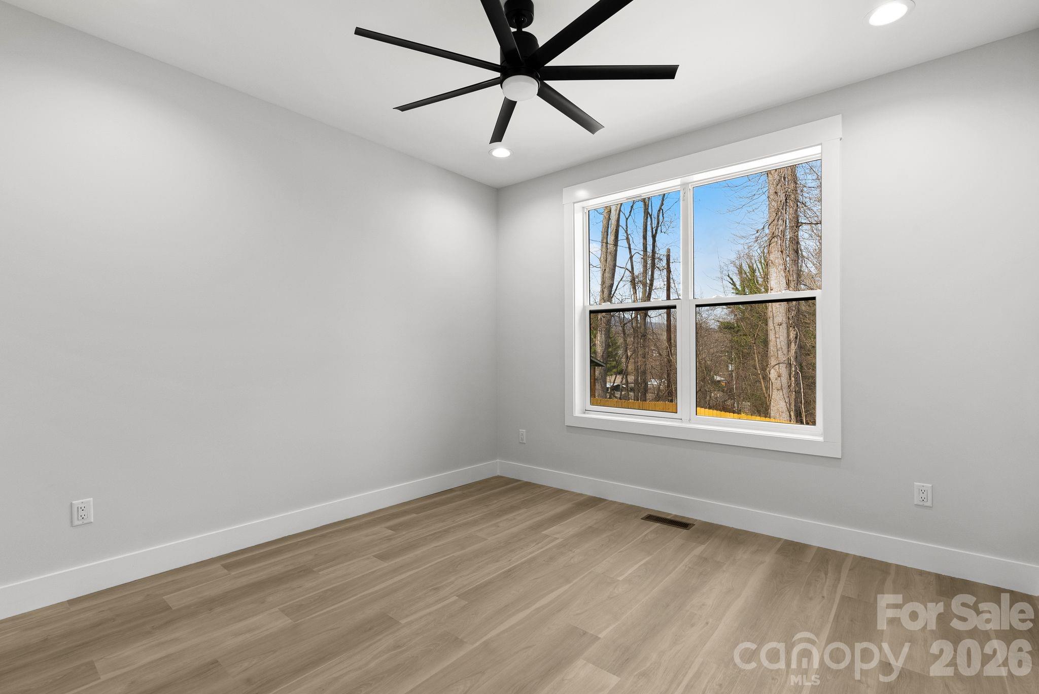 19 East Starnes Cove Road Asheville, NC 28806 - Photo 26 of 46 a view of an empty room with a window and wooden floor