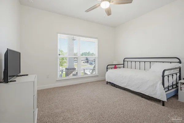 a white bed sitting in a room next to a window