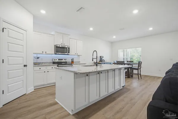 a kitchen with kitchen island granite countertop a sink counter top space and stainless steel appliances