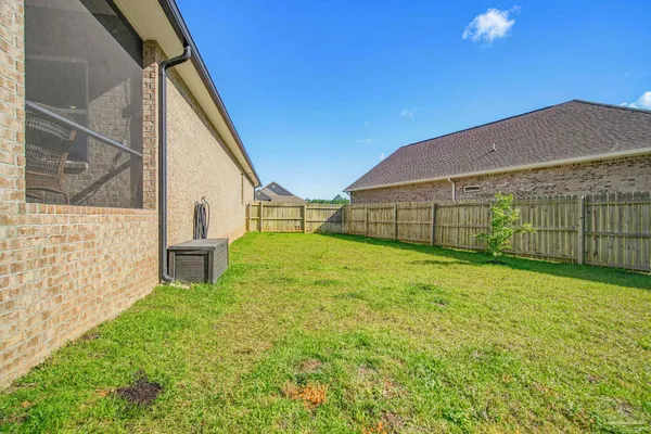 a view of a backyard with a garden and wooden fence