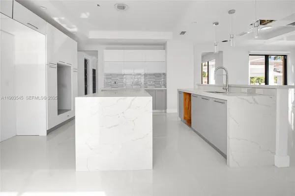 a large white kitchen with cabinets