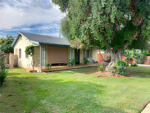 a view of a house with a yard and tree s
