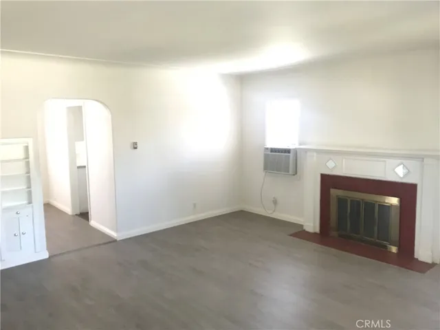 an empty room with a fireplace and a window