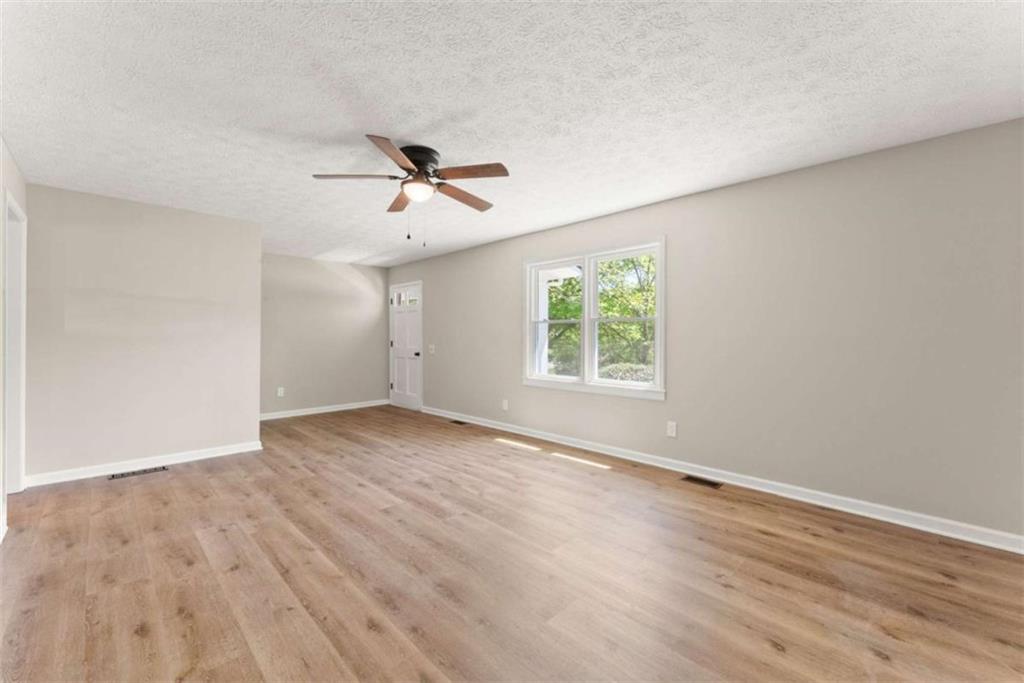 217 Quail Trail Cornelia, GA 30531 - Photo 12 of 48 an empty room with wooden floor ceiling fan and windows