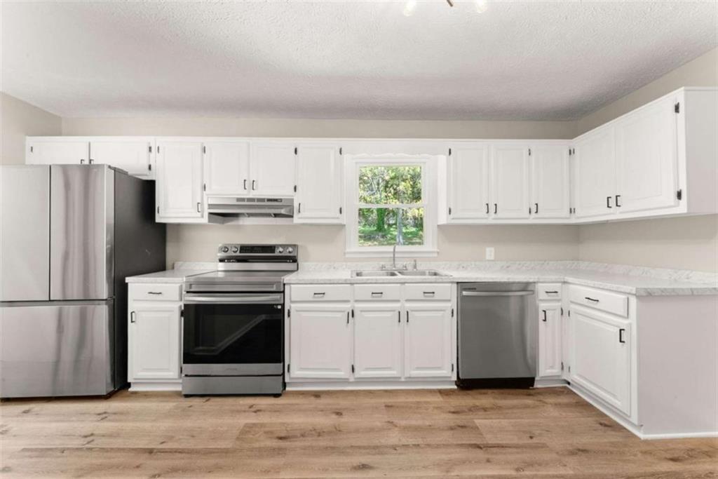 217 Quail Trail Cornelia, GA 30531 - Photo 19 of 48 a kitchen with stainless steel appliances a stove a sink and a refrigerator