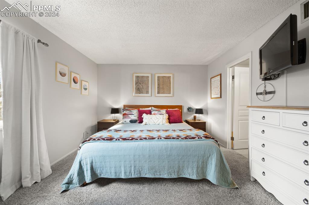 2949 Mesa Road, Unit C Colorado Springs, CO 80904 - Photo 17 of 28 a bedroom with a bed a flat screen tv and dresser