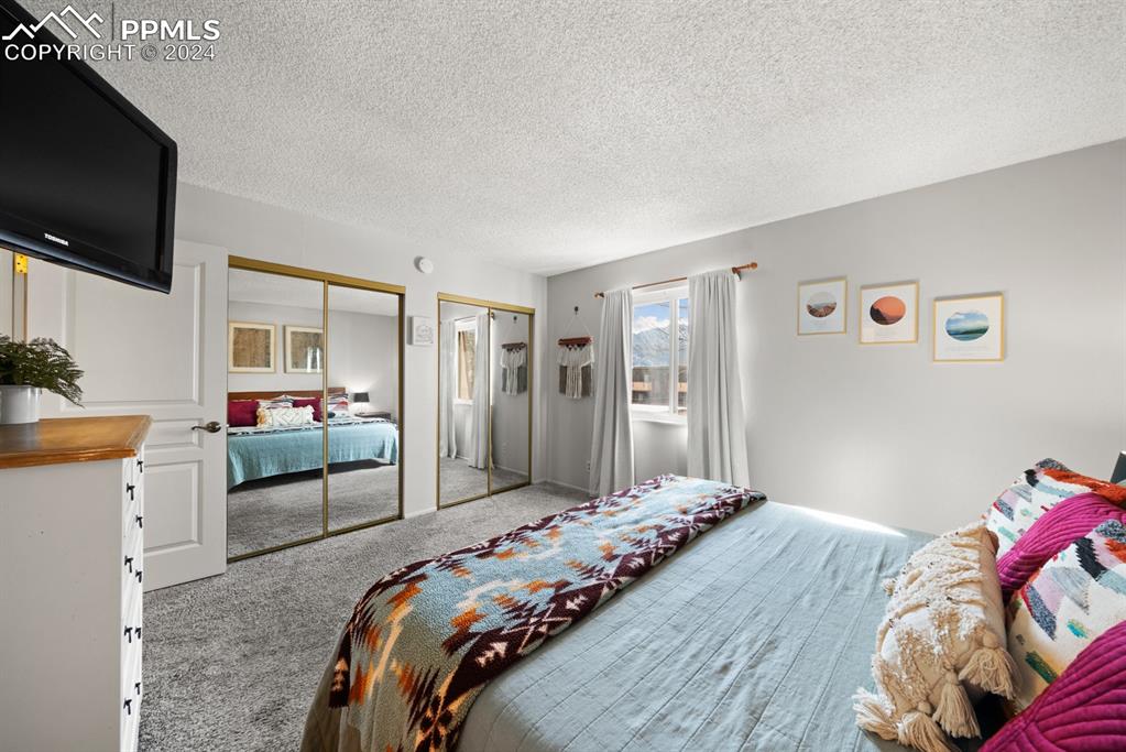 2949 Mesa Road, Unit C Colorado Springs, CO 80904 - Photo 19 of 28 a bedroom with a bed and a flat tv screen on wall