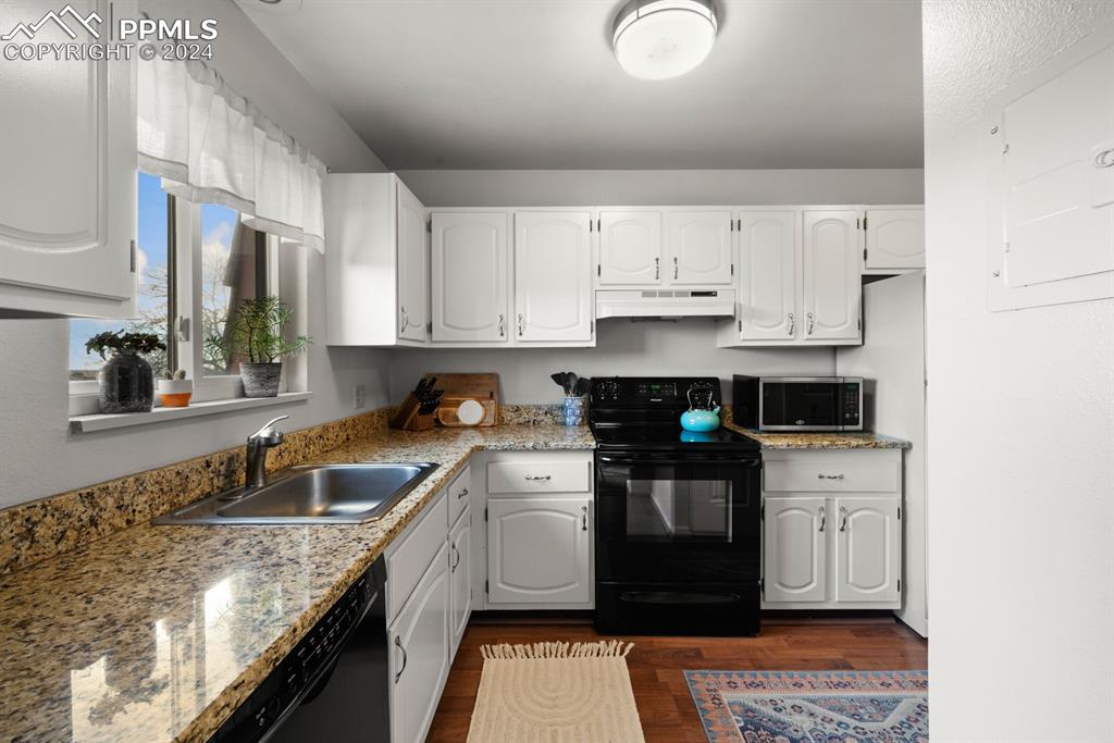 2949 Mesa Road, Unit C Colorado Springs, CO 80904 - Photo 10 of 28 a kitchen with stainless steel appliances granite countertop a sink stove and cabinets
