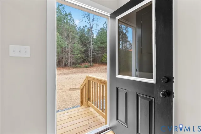 a view of an empty room with wooden floor and window