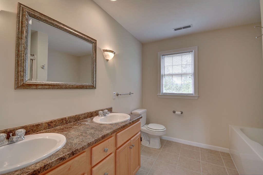 67 Arnold Road Sturbridge, MA 01518 - Photo 22 of 29 a bathroom with a granite countertop sink toilet and mirror