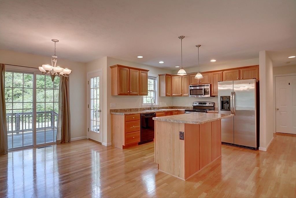 67 Arnold Road Sturbridge, MA 01518 - Photo 3 of 29 a kitchen with stainless steel appliances granite countertop a refrigerator a sink dishwasher a stove and a dining table with wooden floor