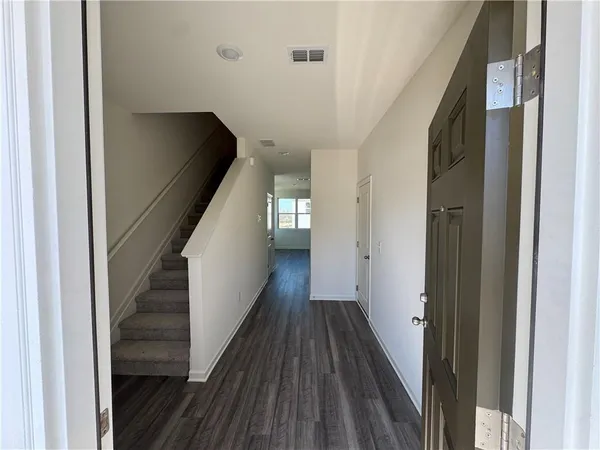 a view of a hallway with wooden floor and staircase