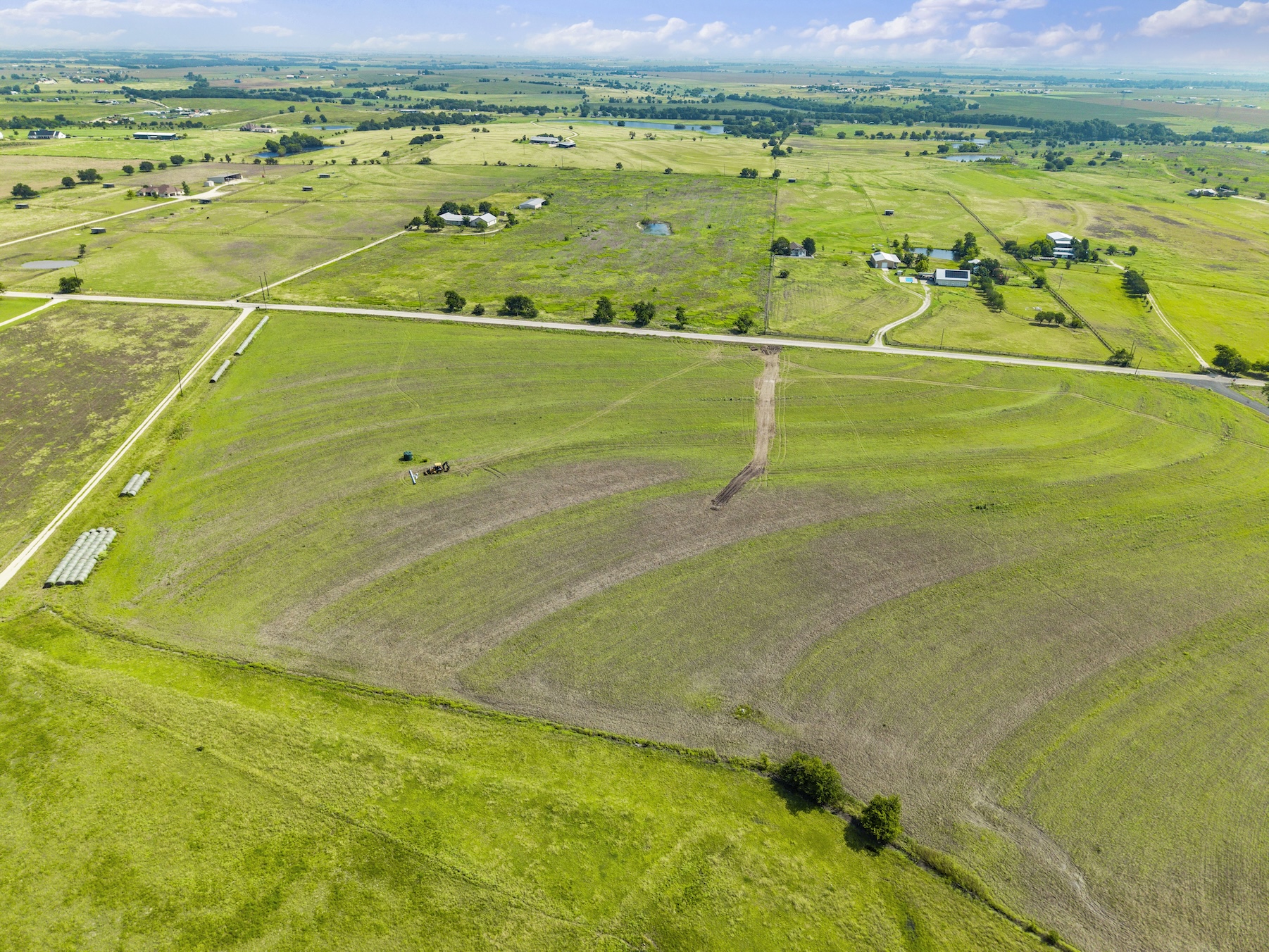 1 County Road 327 Road Granger, TX 76530 - Photo 24 of 27 Vast rolling green pastures stretch toward the horizon under a soft, cloud-filled sky.