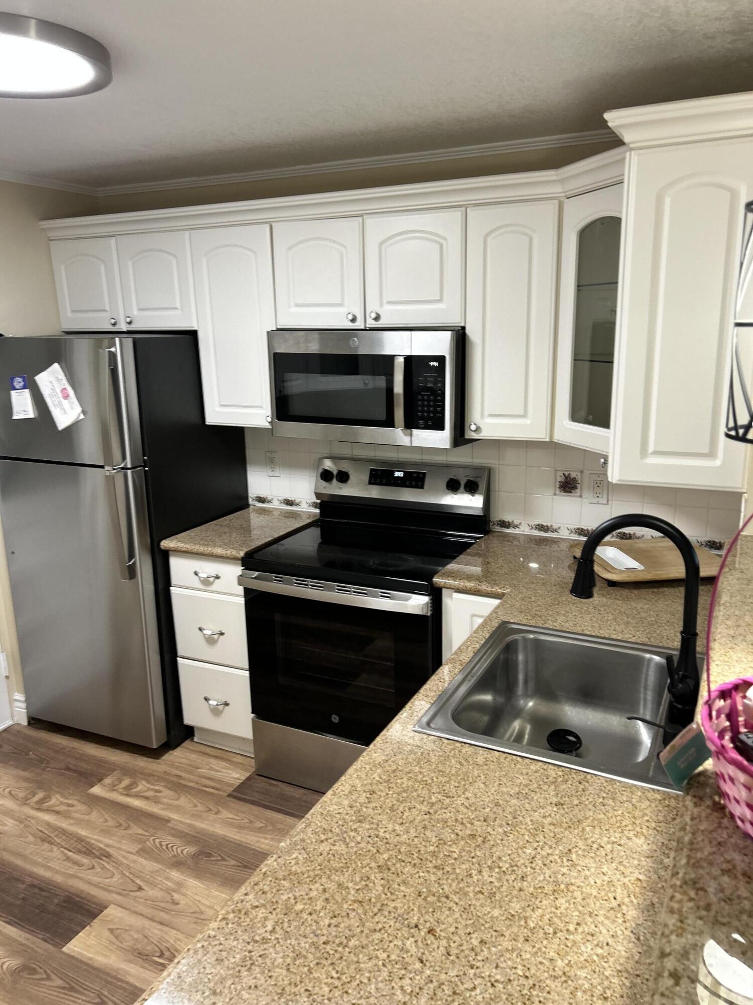 5201 Northwest 2nd Avenue, Unit 112 Boca Raton, FL 33487 - Photo 1 of 40 a kitchen with stainless steel appliances granite countertop a refrigerator stove a sink dishwasher and microwave oven