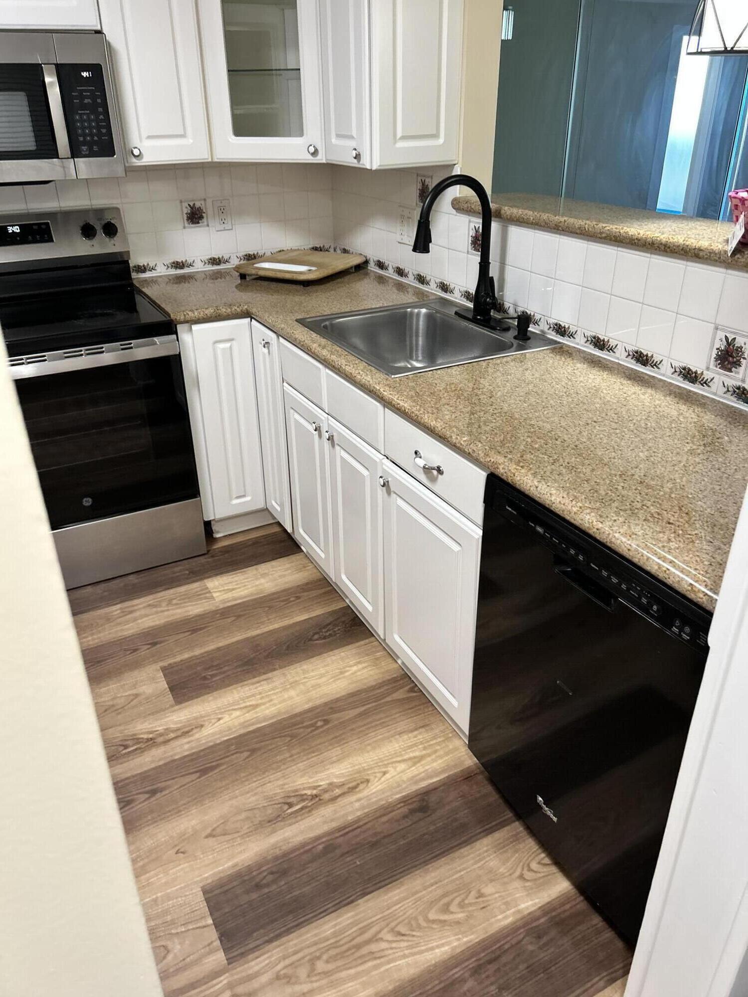 5201 Northwest 2nd Avenue, Unit 112 Boca Raton, FL 33487 - Photo 3 of 40 a kitchen with granite countertop a sink and a stove
