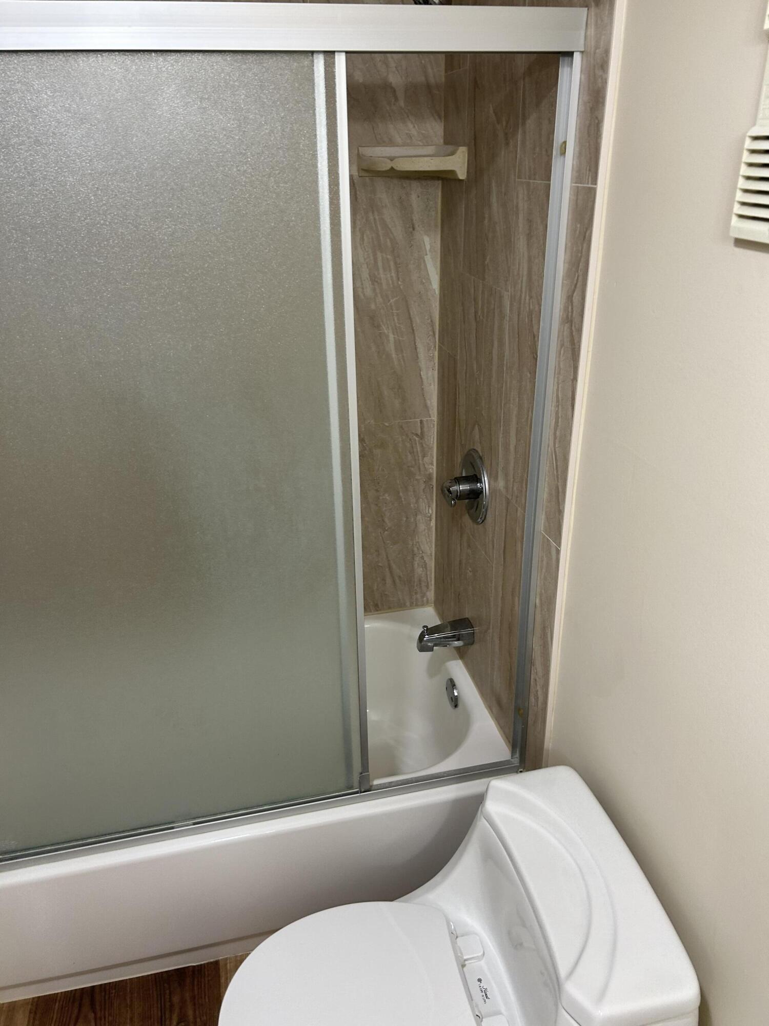 5201 Northwest 2nd Avenue, Unit 112 Boca Raton, FL 33487 - Photo 32 of 40 a white toilet sitting next to a bath tub