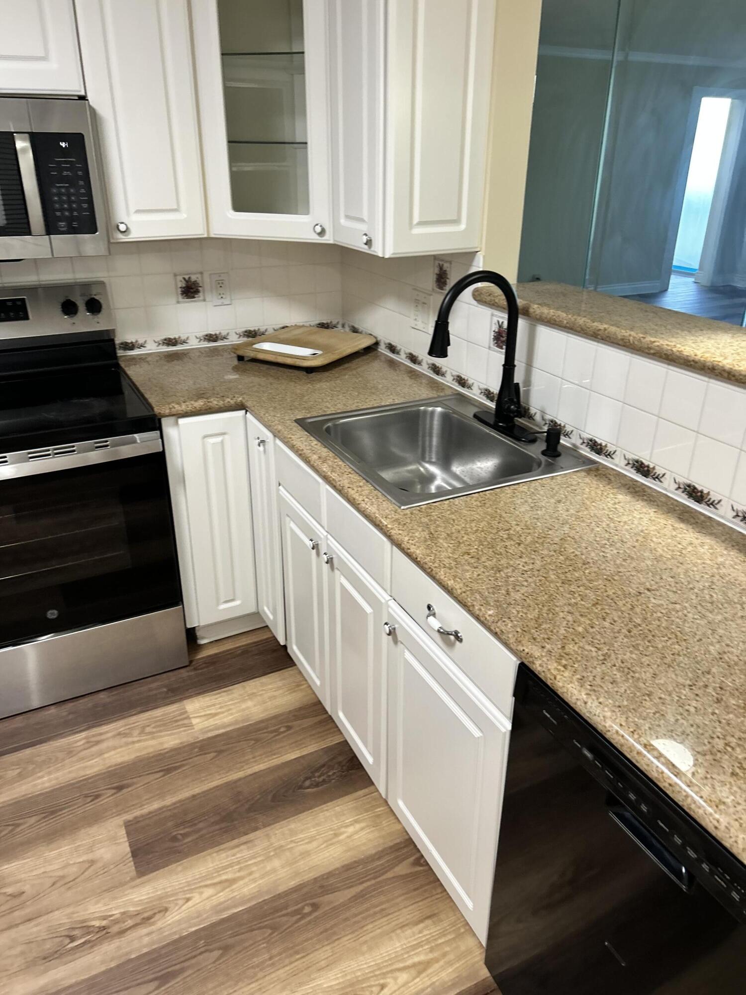 5201 Northwest 2nd Avenue, Unit 112 Boca Raton, FL 33487 - Photo 7 of 40 a kitchen with granite countertop a sink a stove and cabinets