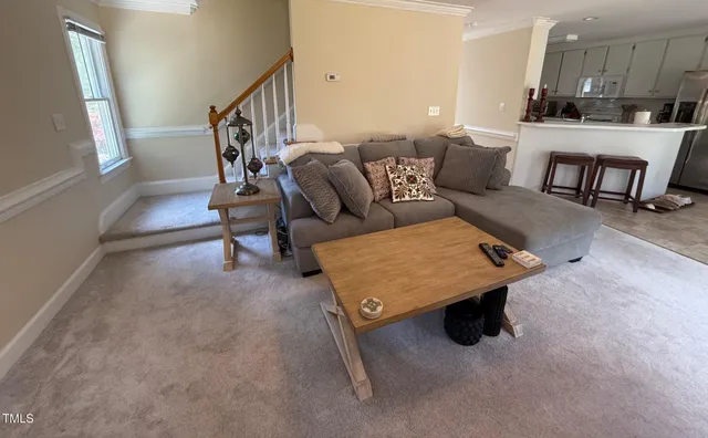 a living room with furniture and a dining table with kitchen view