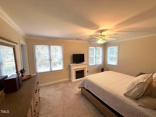 a bedroom with a large bed and a flat tv screen on dresser