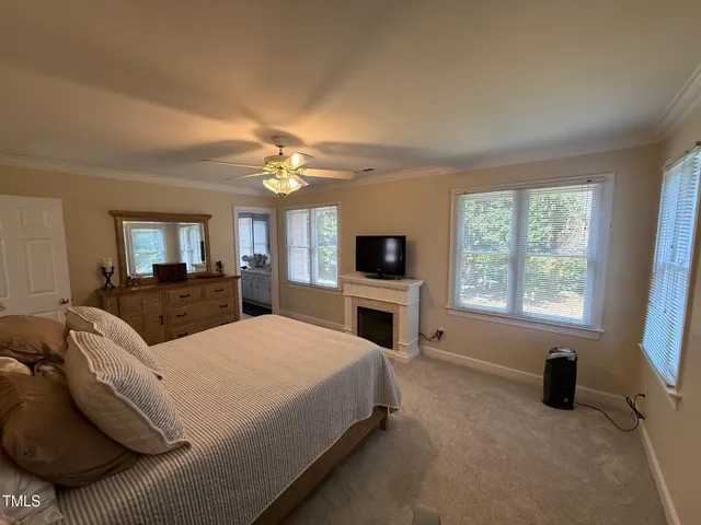 a large bedroom with a large bed a flat tv screen and a fireplace