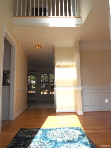 a view of a hallway with wooden floor and a rug