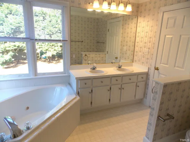 a bathroom with a tub sink and mirror