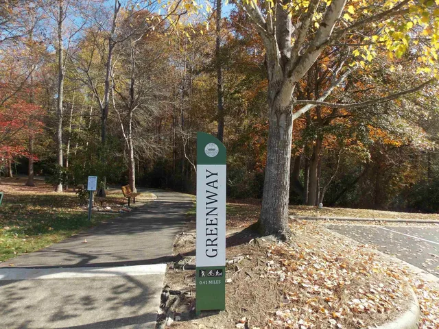 a street sign on a sidewalk next to a road
