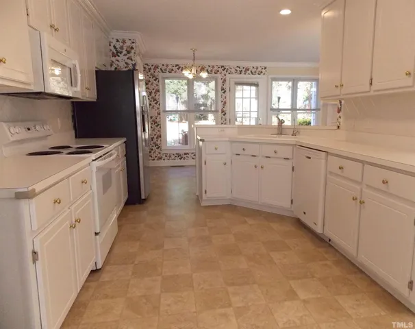a kitchen with white cabinets and white appliances
