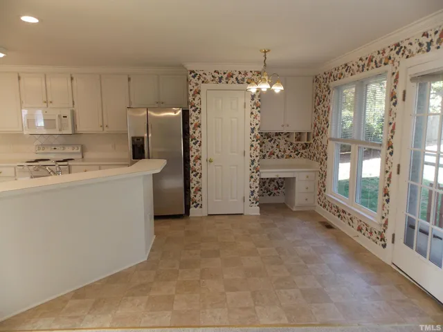a view of a kitchen with refrigerator and windows
