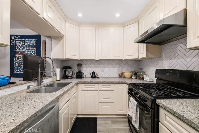 a kitchen with stainless steel appliances granite countertop a sink and a refrigerator