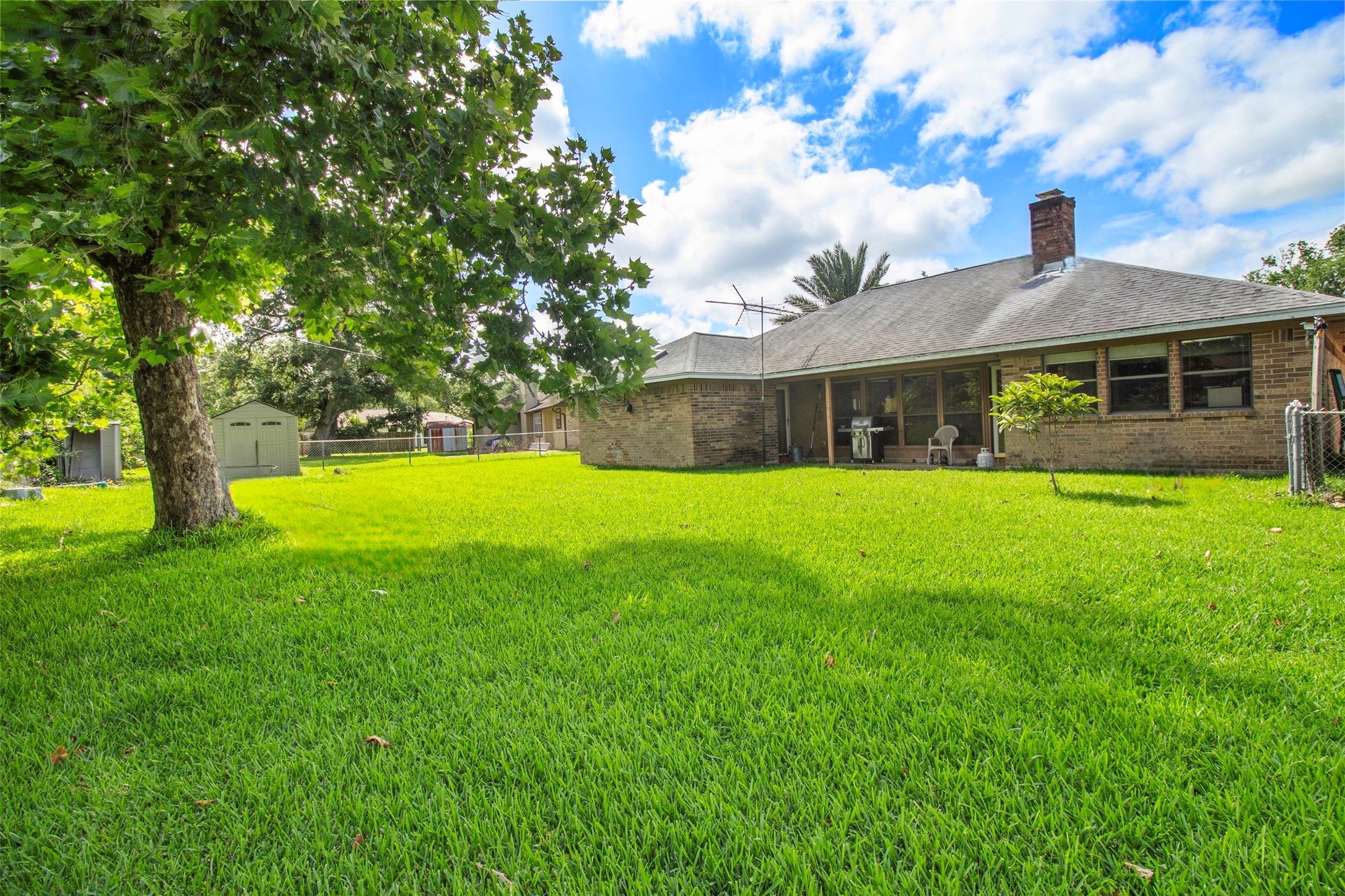 206 Stanford Road Lake Jackson, TX 77566 - Photo 23 of 26 a view of a house with a big yard potted plants and large tree
