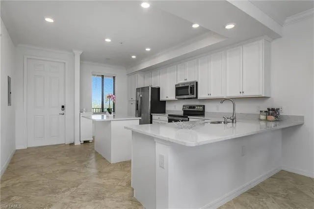 a large kitchen with kitchen island a sink stainless steel appliances and cabinets