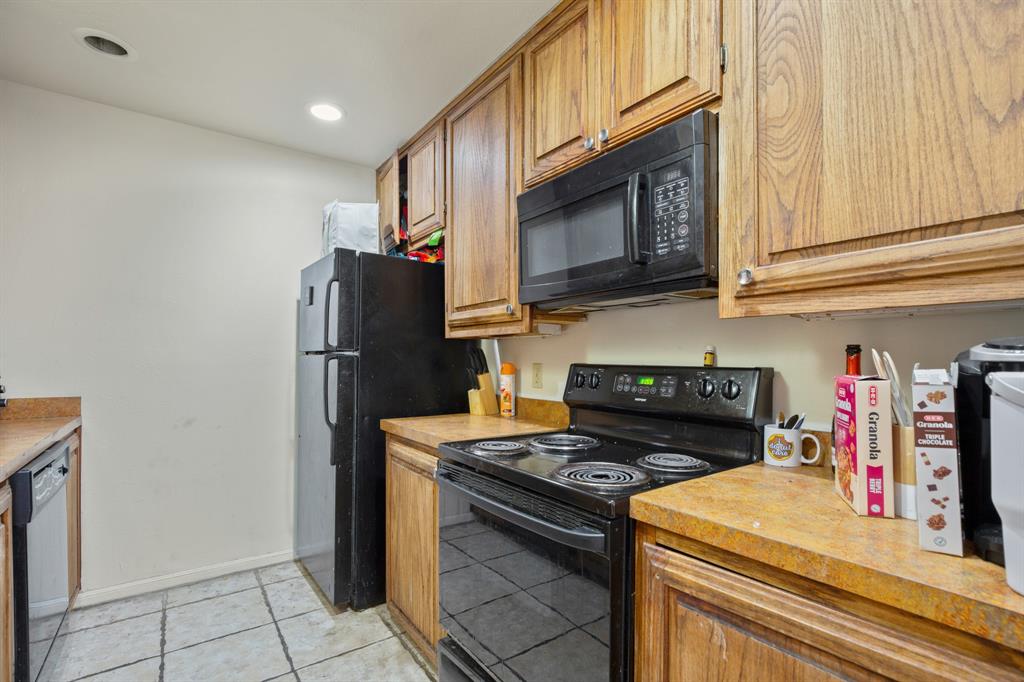 2529 Rio Grande Street, Unit 7 Austin, TX 78705 - Photo 6 of 13 a kitchen with stainless steel appliances granite countertop a refrigerator and a stove top oven