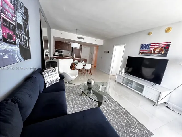 a lobby with furniture potted plants and a table