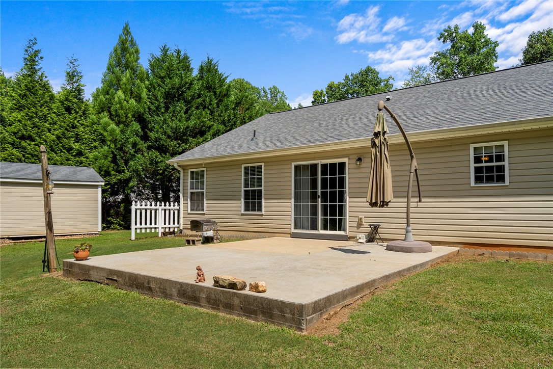 167 Mediterranean Avenue Anderson, SC 29621 - Photo 28 of 33 A spacious concrete patio awaits outdoor entertaining, complemented by a private, fenced yard and mature landscaping.
