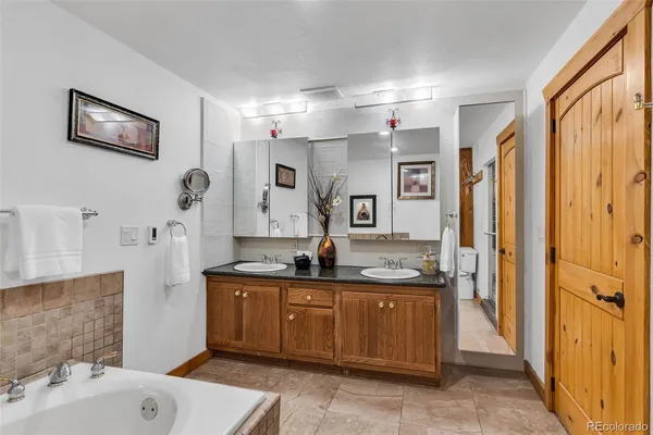 a bathroom with a granite countertop sink a mirror and a shower