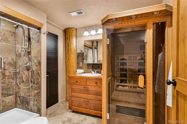 a bathroom with a shower a mirror and a sink