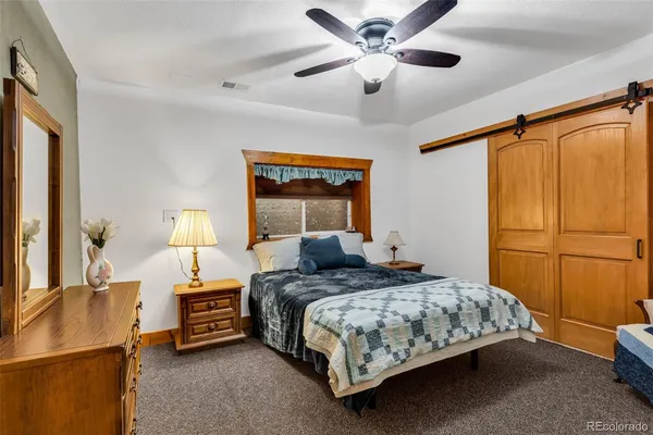 a bedroom with a bed chandelier and a window