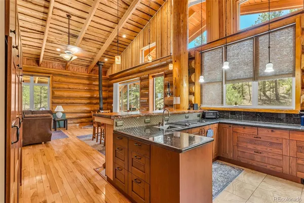 a kitchen that has a sink and chairs in it