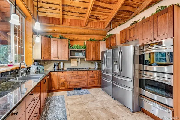 a kitchen with stainless steel appliances granite countertop a refrigerator and a stove