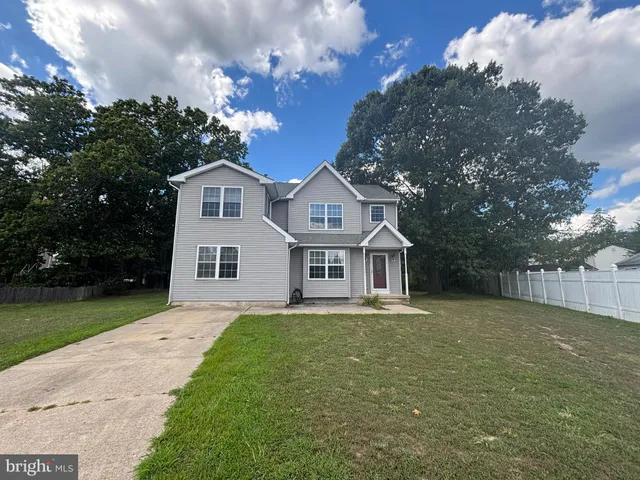 a front view of a house with a garden and trees