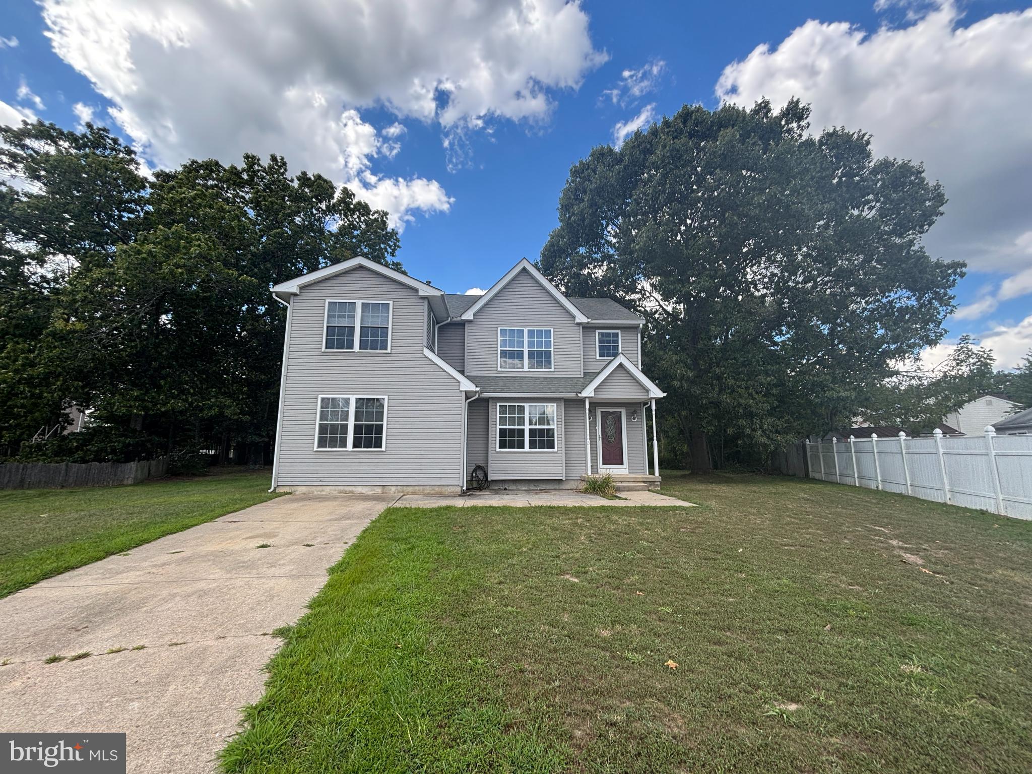 a front view of a house with a garden and trees