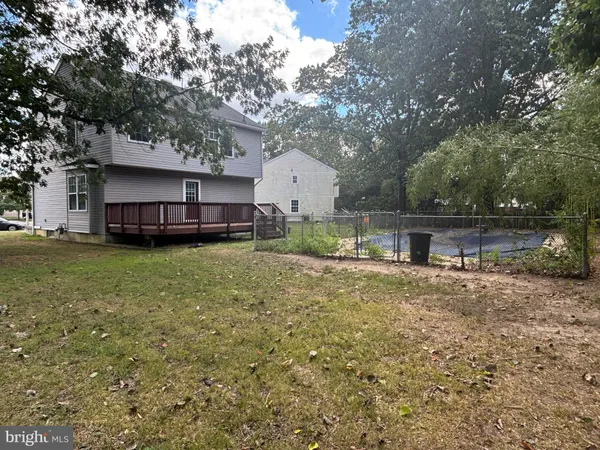 a view of a house with a yard and large tree